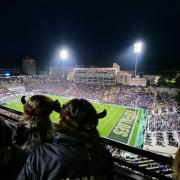 Football fans wearing Buffalo hats watch the game 