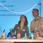 Two faculty members present a electrical light-based experiment.