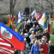 People walking between a row of flags during the Conference on World Affairs