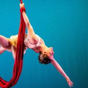 Danielle Garrison hanging a red fabric drape