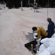 a scientist sampling dust in a snowy alpine environment