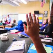 student raises hand in classroom