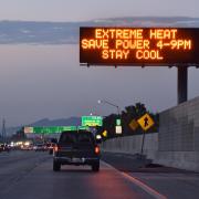 Highway road sign reads: "Extreme heat. Save power 4-9 p.m. Stay cool."