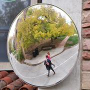 students walking on campus as seen reflected in a mirror