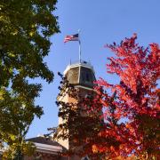 Top of Old Main building framed with fall leaves