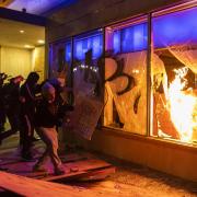 Protesters smash the window of a Chase bank during protests in Oakland