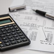 calculator, budget sheet and pen
