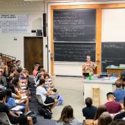 Instructor leads class in a large lecture hall