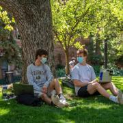 two people in masks talking on campus