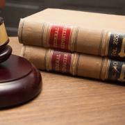 A judge's gavel sits next to stack of law books