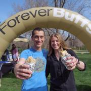 2022 graduating students enjoy free breakfast burritos in front of a Forever Buffs sign