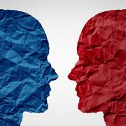 Stock image of a blue head and red head facing off