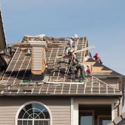 A crew builds the roof of a house.