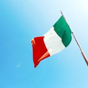 Italian flag flies in clear blue sky