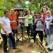 John Zhai (center) measures air quality with community members in Indonesia
