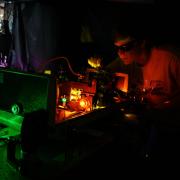 Student working on a laser in a lab at JILA