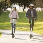 Stock image of people riding Lime Scooters