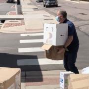 A person loading PPE supplies into a truck