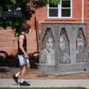 A person walks by the Los Seis de Boulder sculpture on the CU Boulder campus.