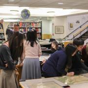 Students analyze maps in the library