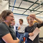 Researcher holds a test tube up to Mija Hubler