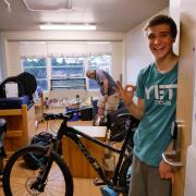Student moving into dorm room with bicycle in background