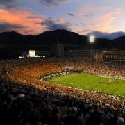 Fans cheer as the sun sets at Folsom Field