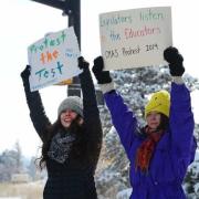 Protestors display "Protest the test" signs