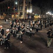 The CU marching band parades down Pearl Street