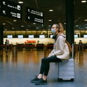person sitting in airport wearing a mask