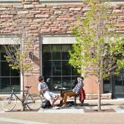 two people sitting at a table outside on campus