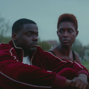 Slim and Queen standing against a fence talking