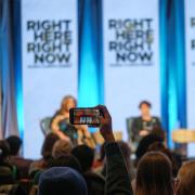 A guest takes a smartphone photos of the panel discussion (1.2) on the Experiences of Those Whose Human Rights Are Disproportionately Impacted by Climate Change at the Right Here Right Now Climate Summit at the Glenn Miller Ballroom in the University Memorial Center on the CU Boulder campus on Dec. 2, 2022. (Photo by Glenn Asakawa/University of Colorado)