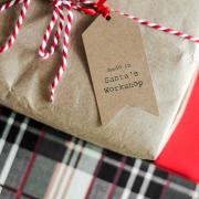 Christmas present wrapped in brown paper with festive string and handmade gift tag