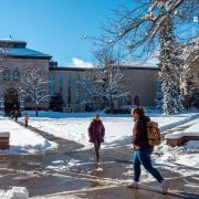 Students walk across a snowy campus