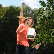 Student jumps in the air holding scholarship notification