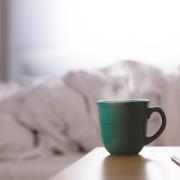 Hot cup of a coffee on a bedside table