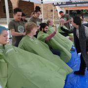 Brittany Ross, right, who is a 17 year cancer survivor, gives high-fives to students participating in a Saint Baldrick's event outside the UMC at the University of Colorado Boulder.  (Photo by Casey A. Cass/University of Colorado)