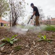 Facilities Management staff members treats weeds with steam on campus