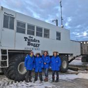 Students pose in front of the Arctic Tundra Buggy