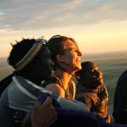 Students and locals watching the sunset in Tanzania