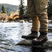 Someone standing on a stone in a river during a hike