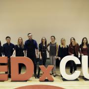 Committee executives pose for a photo in front of the TEDxCU letters