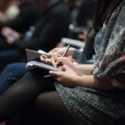 Woman takes notes at informational session