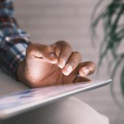 A person's hand hovers over a tablet. (Towfiqu Barbhuiya/Unsplash)