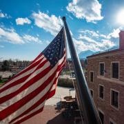 American flag flying on campus with mountains in background