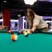 Person playing pool in The Connection
