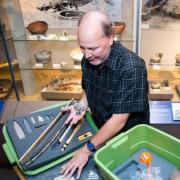 Senior museum educator Jim Hakala, left, and anthropology curator Steve Lekson prepare a fossil kit to be delivered to a Colorado classroom. 