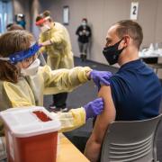 nurse administering a COVID-19 vaccine