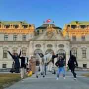 Group of students jumping in front of Belvedere Palace in Vienna, Austria